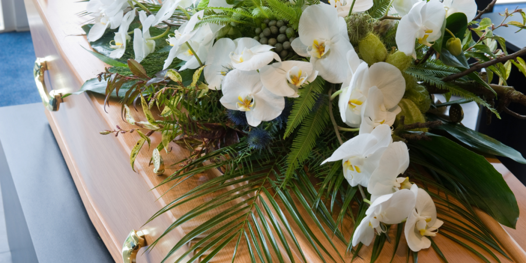 Picture of a coffin with white bouquet of flowers